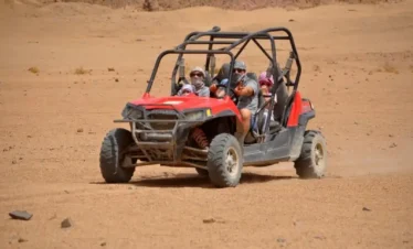 Guests enjoying Buggy Desert Adventure ride and Bedouin tea at sunset in Sharm El Sheikh desert