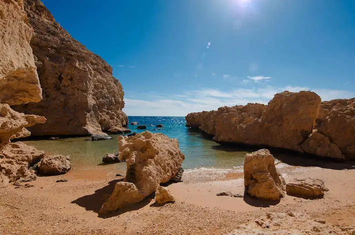 Ras Mohamed Snorkeling Tour: Snorkeling the coral reefs of Ras Mohamed, a colorful underwater view with tropical fish and a person snorkeling above in Ras Mohamed National Park.  