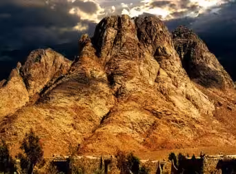 Alt Text: Mount Sinai Egypt at sunrise with hikers overlooking the Sinai Mountains